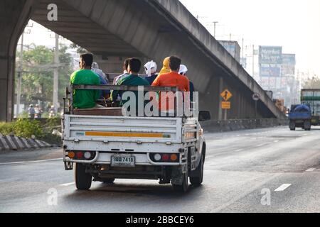 BANGKOK, THAILAND, 16. JANUAR 2020, Menschen fahren im Laderaum des Autos. Männer, die auf einem Laderaum eines Pickup-Wagens auf der Straße in Bangkok sitzen. Stockfoto