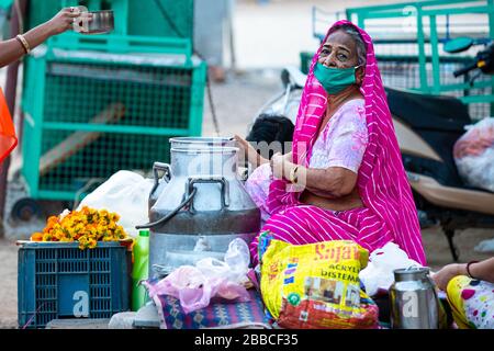 Jodhpur, Rajashtbn, Indien. März 2020. Alte Frau, die eine Schutzmaske trägt, die Lebensmittel auf der Straße aufgrund der Sperrung verkauft, Coronavirus, COVID-19-Ausbruch in i Stockfoto