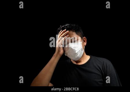 Asiatische Männer tragen Masken, um die Grippe zu verhindern, mit Kopfschmerzen Stockfoto