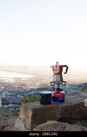 Kapstadt, Südafrika. März 2020. Eine Mokka kleine Espressomaschine auf einem kleinen Gaskochofen und einem Kaffeebecher für eine tragbare Kaffeemaschine Stockfoto