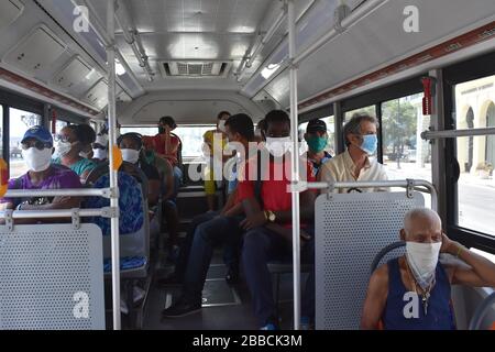 Havanna, Kuba. März 2020. Menschen, die Masken tragen, nehmen einen Bus in Havanna, Kuba, 30. März 2020. Credit: Zhu Wanjun/Xinhua/Alamy Live News Stockfoto