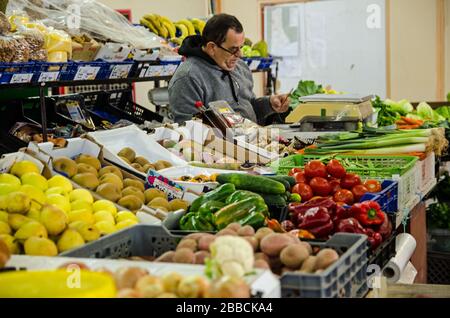 Monte Gordo, Portugal - 18. November 2019: Stallholder verwaltet seinen Frischvermarktungsstand auf dem Indoor-Markt am Badeort Monte Gordo an t Stockfoto