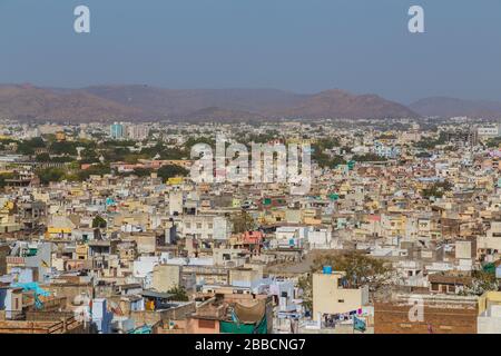 UDAIPUR, INDIEN - 21. MÄRZ 2016: Ein Blick über Dächer im Zentrum von Udaipur am Morgen. Die Machla Hills sind in der Ferne zu sehen. Stockfoto