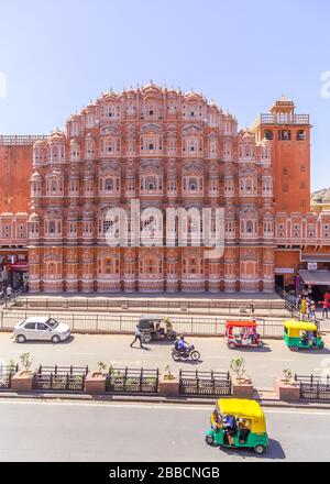 JAIPUR, INDIEN - 22. MÄRZ 2016: Die Front des Hawa Mahal (Palast der Winde) im Zentrum von Jaipur. Tuk Tuks, anderer Verkehr und Menschen sind zu sehen Stockfoto