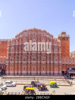 JAIPUR, INDIEN - 22. MÄRZ 2016: Die Front des Hawa Mahal (Palast der Winde) im Zentrum von Jaipur. Tuk Tuks, anderer Verkehr und Menschen sind zu sehen Stockfoto