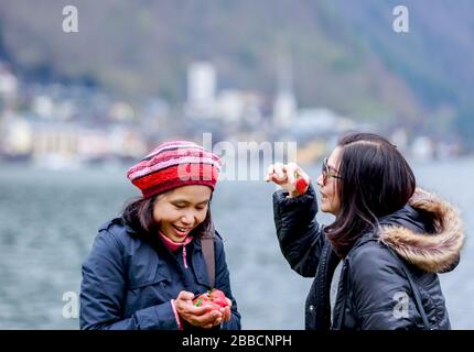 Zwei weibliche Freunde teilen gerne Erdbeeren Stockfoto