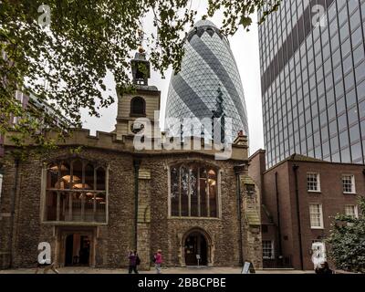 Alt trifft neue - Fassade der St Helen's Church Bishopsgate mit dem Gherkin-Wolkenkratzer im Hintergrund, London, England Stockfoto