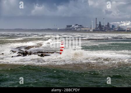 Raue Meere am rot-weißen Leuchtturm am Pier von IJmuiden, an der Einmündung des Nordseekanals, Noordpier, Reyndersweg Niederlande Stockfoto