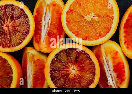 Draufsicht auf frische orangefarbene Bluthälften und Quater. Fruchthintergrund Stockfoto