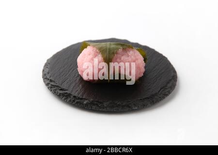 sakura mochi Reiskuchen japanische Süßwaren auf Platte isoliert auf weißem Hintergrund Stockfoto