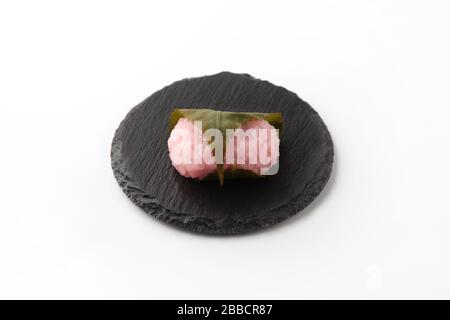 sakura mochi Reiskuchen japanische Süßwaren auf Platte isoliert auf weißem Hintergrund Stockfoto