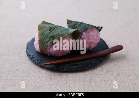 sakura mochi Reiskuchen japanische Süßwaren auf Platte isoliert auf Tischtuch Stockfoto