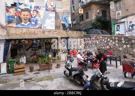 Kartenspiele im spanischen Viertel von Neapel unter einem Plakat der Spieler des Fußballclubs Napoli Stockfoto