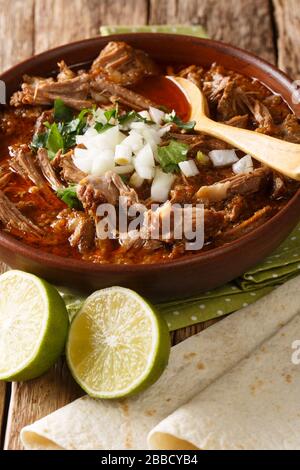 Birria de Res ist ein traditioneller mexikanischer Eintopf, das perfekte Komfort-Essen mit kräftigen Aromen in einer Schüssel auf dem Tisch. Vertikal Stockfoto