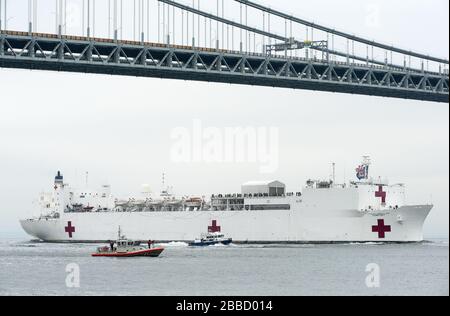 NEW YORK, NY - 30. MÄRZ: Das Militär-Sealift-Kommando-Lazarettschiff USNS Comfort (T-AH 20) wird von der US-Küstenwache, der New Yorker Polizeibehörde und den Anlagen der New Yorker Feuerwehr begleitet, wenn das Schiff in New York City, 30. März 2020 ankommt. Komfort, der zur Unterstützung der COVID-19-Reaktionsbemühungen des Landes eingesetzt wird und als Überweisungskrankenhaus für nicht-COVID-19-Patienten dient, die derzeit in Landkrankenhäusern eingeliefert werden. So können Krankenhäuser in Landhäusern ihre Bemühungen auf COVID-19-Fälle konzentrieren. Eine der Missionen des Verteidigungsministeriums ist die Verteidigungsunterstützung von Zivilbehörden. DoD wird unterstützt Stockfoto