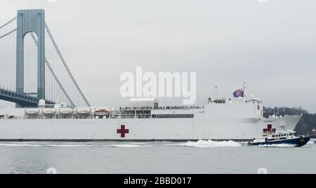 NEW YORK, NY - 30. MÄRZ: Das Militär-Sealift-Kommando-Lazarettschiff USNS Comfort (T-AH 20) wird von der US-Küstenwache, der New Yorker Polizeibehörde und den Anlagen der New Yorker Feuerwehr begleitet, wenn das Schiff in New York City, 30. März 2020 ankommt. Komfort, der zur Unterstützung der COVID-19-Reaktionsbemühungen des Landes eingesetzt wird und als Überweisungskrankenhaus für nicht-COVID-19-Patienten dient, die derzeit in Landkrankenhäusern eingeliefert werden. So können Krankenhäuser in Landhäusern ihre Bemühungen auf COVID-19-Fälle konzentrieren. Eine der Missionen des Verteidigungsministeriums ist die Verteidigungsunterstützung von Zivilbehörden. DoD wird unterstützt Stockfoto