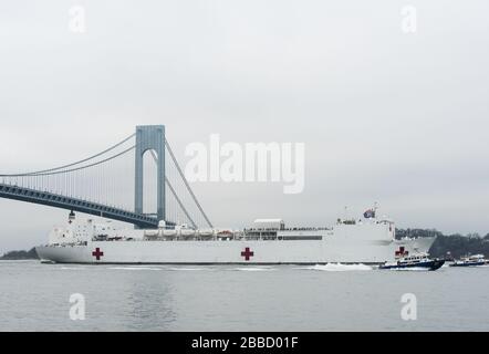 NEW YORK, NY - 30. MÄRZ: Das Militär-Sealift-Kommando-Lazarettschiff USNS Comfort (T-AH 20) wird von der US-Küstenwache, der New Yorker Polizeibehörde und den Anlagen der New Yorker Feuerwehr begleitet, wenn das Schiff in New York City, 30. März 2020 ankommt. Komfort, der zur Unterstützung der COVID-19-Reaktionsbemühungen des Landes eingesetzt wird und als Überweisungskrankenhaus für nicht-COVID-19-Patienten dient, die derzeit in Landkrankenhäusern eingeliefert werden. So können Krankenhäuser in Landhäusern ihre Bemühungen auf COVID-19-Fälle konzentrieren. Eine der Missionen des Verteidigungsministeriums ist die Verteidigungsunterstützung von Zivilbehörden. DoD wird unterstützt Stockfoto