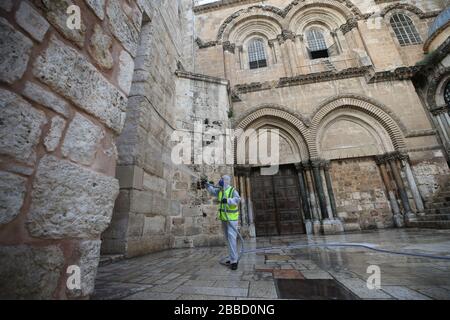 Jerusalem. März 2020. Ein Arbeiter reinigt den platz außerhalb der Grabeskirche in der Altstadt von Jerusalem inmitten einer Coronavirus-Epidemie am 30. März 2020. Credit: Muammar Awad/Xinhua/Alamy Live News Stockfoto