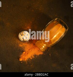 Konzept gesundes Essen. Gewürz aus Turmerischem Pulver in Glasbehältern auf dunklem Hintergrund. Pflanzenheilkunde. Draufsicht. Stockfoto