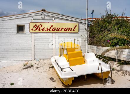 Strandbar, Tretboote, Sonnenschirme und andere Dinge in der Vorsaison am Strand am Golfo aranci in Figari auf Sardinien, Italien Stockfoto