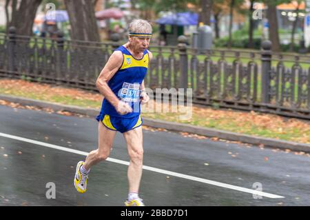 DNIPRO, UKRAINE - 16. SEPTEMBER 2018: Cacasian Senior läuft auf einer Straße in der Stadt während 21 km Entfernung vom ATB Dnipro Marathon Stockfoto