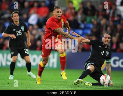 Der Wales Jack Collison (links) und der John O'Shea (rechts) kämpfen während des Internationalen Freundschaftsspiel im Cardiff City Stadium um den Ball. Stockfoto