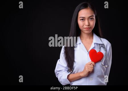 Junge Asian Woman Doktor als Kardiologe, der Herz hält Stockfoto