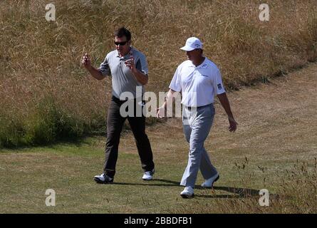 Sir Nick Faldo (links) und Ernie Els gehen während des dritten Übungstages für die Open Championship 2013 im Muirfield Golf Club, East Lothian, die Fairway auf der 4. Bohrung Stockfoto