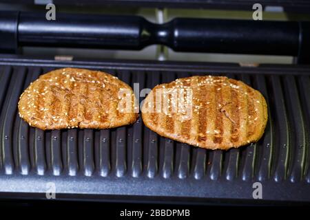Vollkornburger auf elektrischem Grill Stockfoto