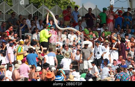 Cricket-Fans machen im vierten Tag des ersten Investec Ashes Test Matches in Trent Bridge, Nottingham, eine Schlange mit Biergläsern aus Kunststoff. Stockfoto