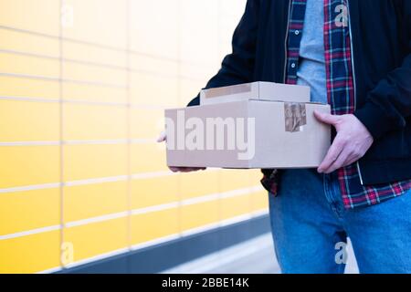 Ein Mann bringt Pakete an eine Verpackungsstation oder holt sie ab Stockfoto