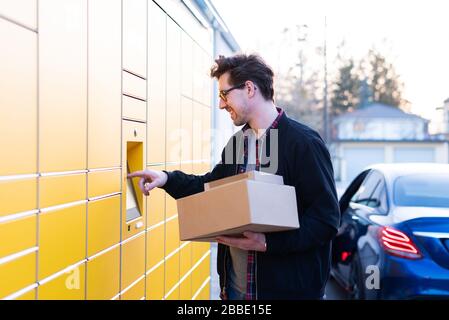 Ein Mann bringt Pakete an eine Verpackungsstation oder holt sie ab Stockfoto