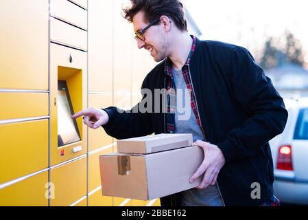 Ein Mann bringt Pakete an eine Verpackungsstation oder holt sie ab Stockfoto