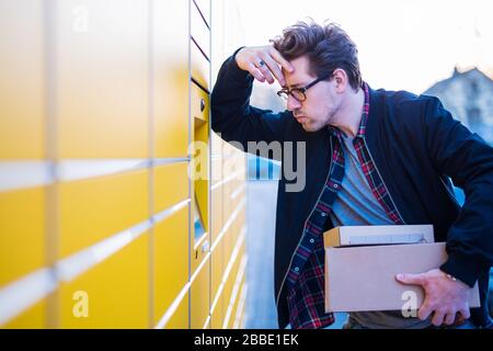 Ein Mann bringt Pakete an eine Verpackungsstation oder holt sie ab Stockfoto