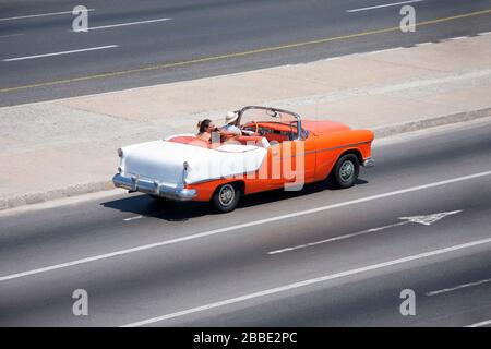 HAVANNA, KUBA - 28. MÄRZ 2017: Touristen an Bord eines klassischen amerikanischen Cabriolet-Wagens aus den 50er Jahren, der auf dem Malecon in Havanna, Kuba, unterwegs ist Stockfoto