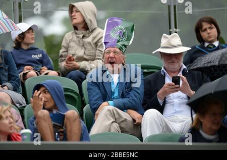 Fans schützen vor dem Regen auf Platz zwei Stockfoto