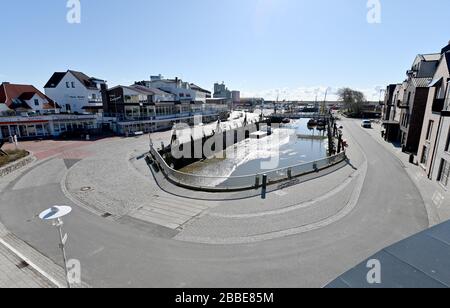 31. März 2020, Schleswig-Holstein, Büsum: Die Straße am Hafen Büsum ist fast menschenleer. Aufgrund der Einschränkungen durch das neue Corona-Virus sind die in den Osterferien normalerweise sehr stark frequentierten Ferienorte an der Küste touristisch frei. Foto: Carsten Rehder / dpa Stockfoto