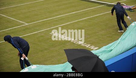 Bodenpersonal bringt die Abdeckungen auf, wenn Regen fällt im AEGON Classic, Edgbaston Priory Club, Birmingham. Stockfoto