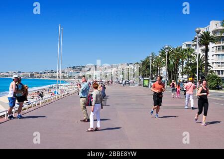 NIZZA, FRANKREICH - 16. MAI: Touristen und Jogger am Meer am 16. Mai 2015 in Nizza, Frankreich. Die lange und berühmte Küste von Nizza, die an die Medite grenzt Stockfoto