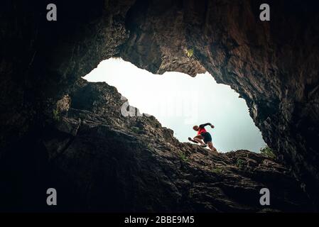 Runner Silhouette, Mann in felsigen Bergen. Ungewöhnliches Sportfoto auf der Spur Stockfoto