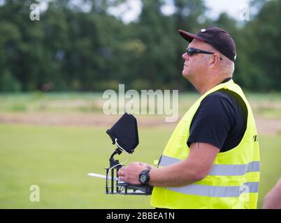 NIJVERDAL, NIEDERLANDE - 23. JUNI 2018: Professioneller Drohnenpilot kontrolliert eine Drohne mit Kamera Stockfoto