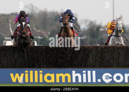 Rennsieger Alasi, der von Dominic Elsworth (C) geritten wurde, springt neben Champion Court, der von Alain Cawley in der Kempton.co.uk Graduation Chase - Horse R geritten wurde Stockfoto