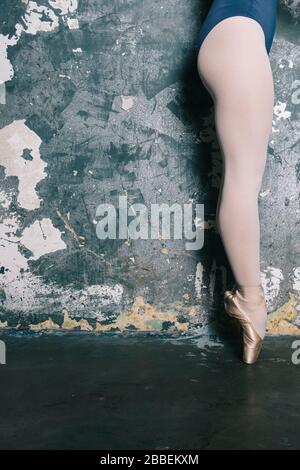 Beine der jungen Ballerina mit pointe-schuhen an der Grunge-Wand Stockfoto