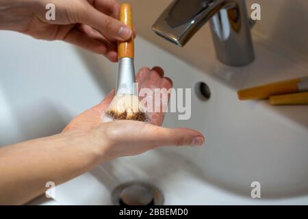 Frauen waschen umweltfreundliche Makeup Pinsel mit Bambusgriffen mit Seife und Wasser. Hygienische Pflege. Stockfoto