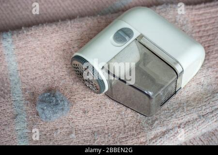 Pullover mit Pillerfüllung. Handgerät für Rasierer mit Fuzz-Entferner zum Entfernen von Fuzz, Flusen und Pillen auf der Kleidung. Stockfoto