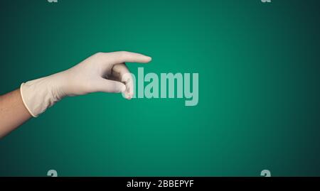 Hand mit Handschuh, der auf den Text zeigt, mit dem Kopieraum für den Text Stockfoto