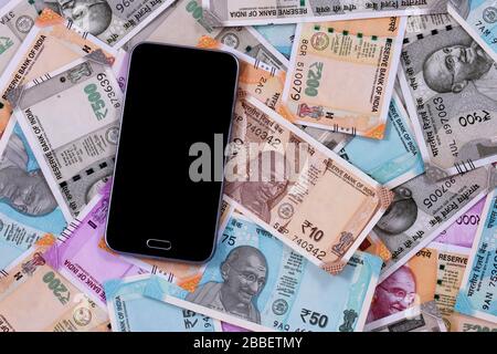 Handy und indische Rupien, digitales Geld, Fin-Tech, Geldverdienen Online-Konzepte. Stockfoto