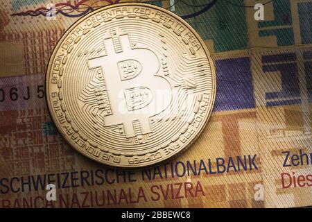 Bitcoin inmitten des Schweizer Frankens, ein wichtiger Plan. Ein Konzept über die Auswirkungen von Währungen auf einander Stockfoto