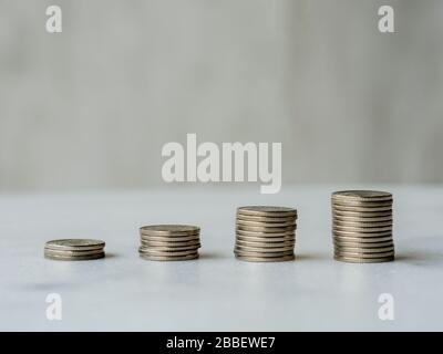 Aufsteigende Münzspalten bilden eine Aufwärtslinie mit Kopierraum. Anschauliches Konzept des Geldwachstums, des wirtschaftlichen Booms oder des finanziellen Gewinns/Gewinns oder des Bankwesens Stockfoto