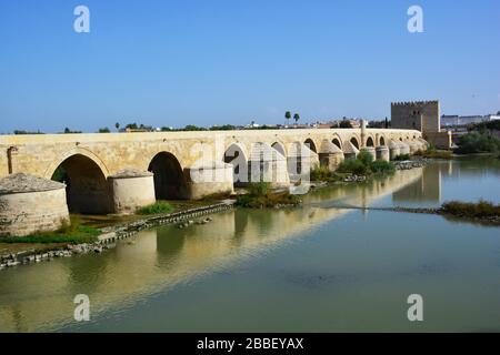 Cordoba, Spanien: Panoramablick auf lange, restaurierte Brücke mit vielen Arkaden und Torturm am Ende der Moschee-Kathedrale von Cor Stockfoto